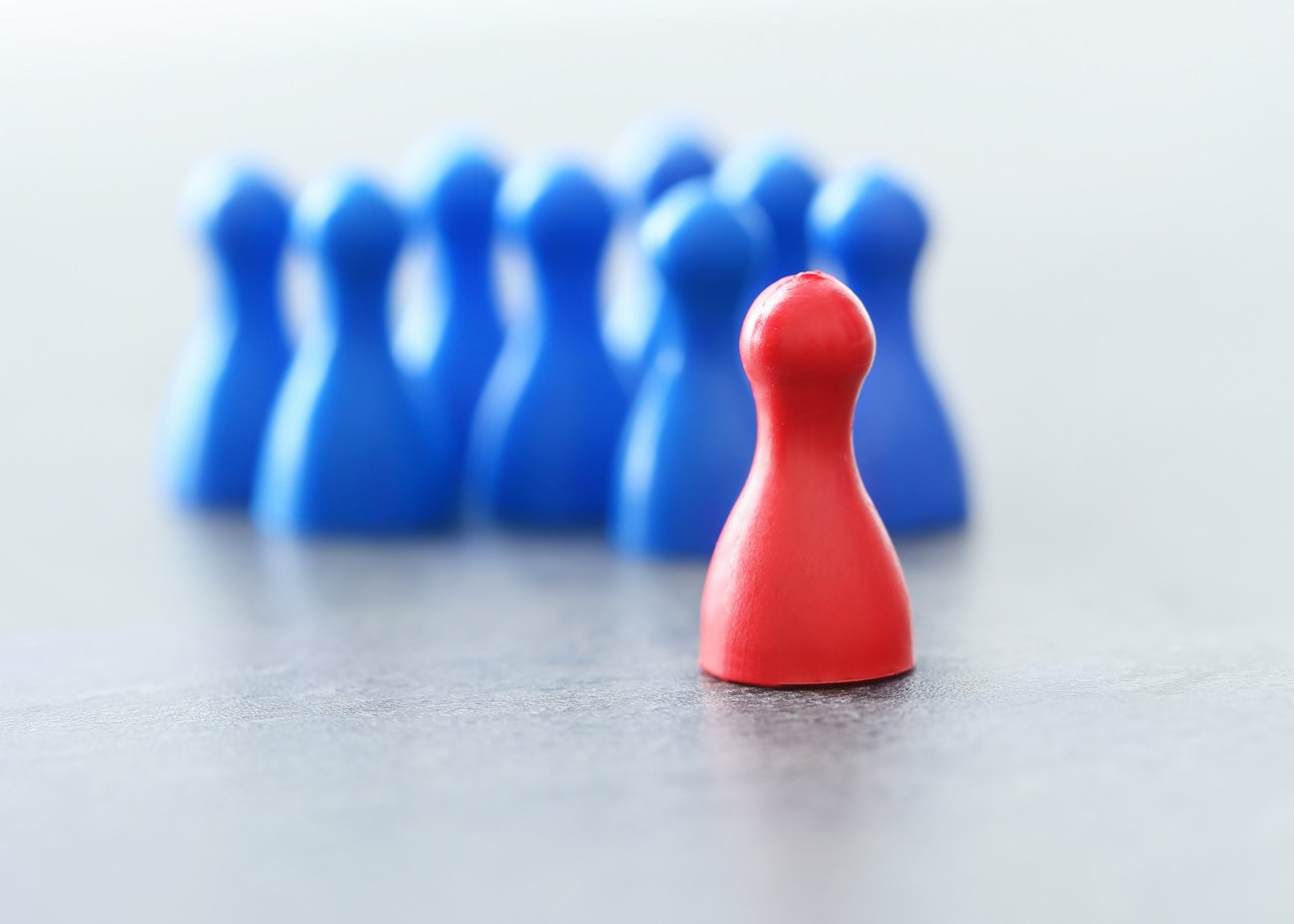 Red Pawn in Front of Blue Ones on Table